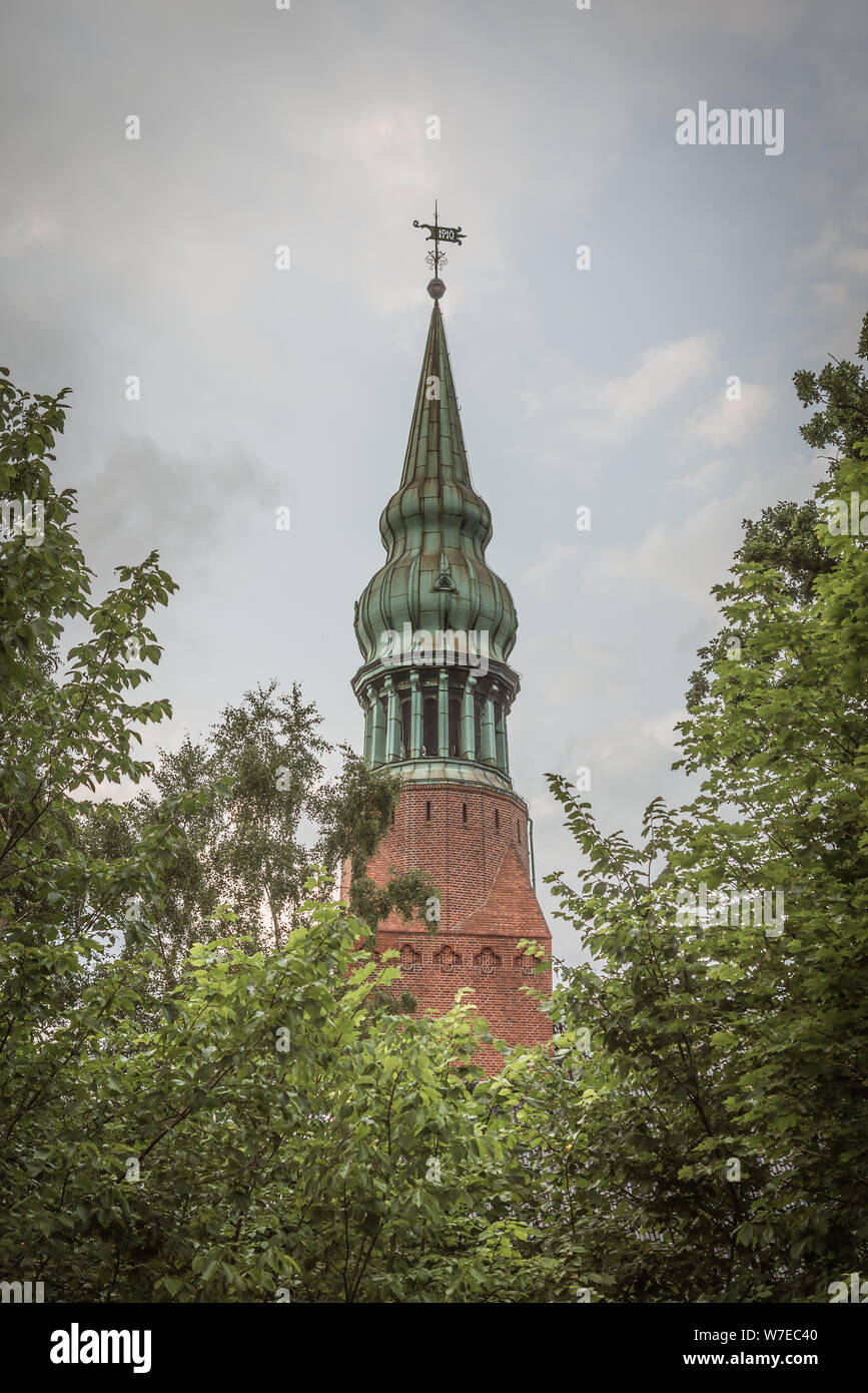 Una guglia di rame su una cupola a cipolla tra il verde degli alberi a frederiksvaerk, Danimarca, luglio 30, 2019 Foto Stock