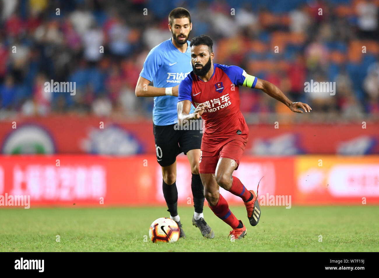 Il calcio brasiliano player Luiz Fernando Pereira da Silva, comunemente noto come Fernandinho, destro di Chongqing SWM passa la palla contro il calcio belga Yannick giocatore Ferreira Carrasco di Dalian Yifang nel loro ventunesimo partita durante il 2019 Chinese Football Association Super League (CSL) a Chongqing Cina, 2 agosto 2019. Dalian Yifang sconfitto Chongqing SWM 3-1. Foto Stock