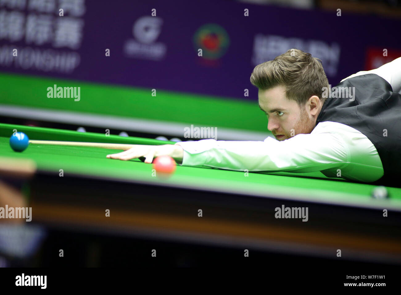 Jak Jones del Galles gioca un colpo di Mark Williams del Galles nel primo round corrispondere durante il 2019 World Snooker Championship internazionale nella città di Daqing, a nord-est della Cina di Provincia di Heilongjiang, 5 agosto 2019. Foto Stock