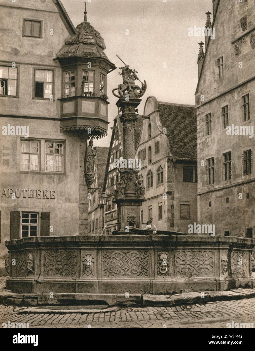 "Rothenburg o. d. T. - San Giorgio - Fontana Marien-Apotheke', 1931. Artista: Kurt Hielscher. Foto Stock