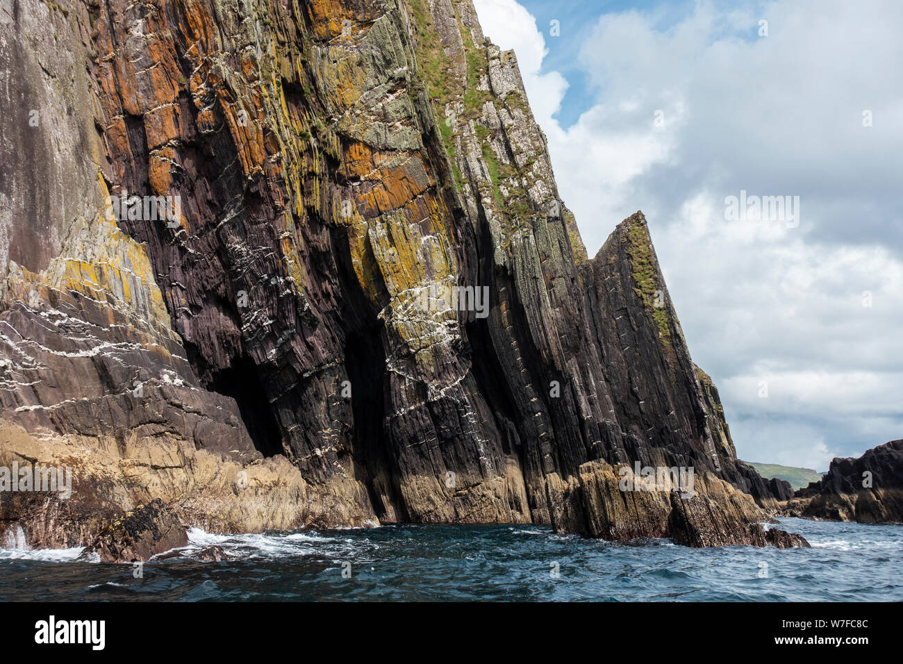 Costa frastagliata di seguito Ballymacadoyle Hill visto dalla barca - Penisola di Dingle, nella contea di Kerry, Repubblica di Irlanda Foto Stock