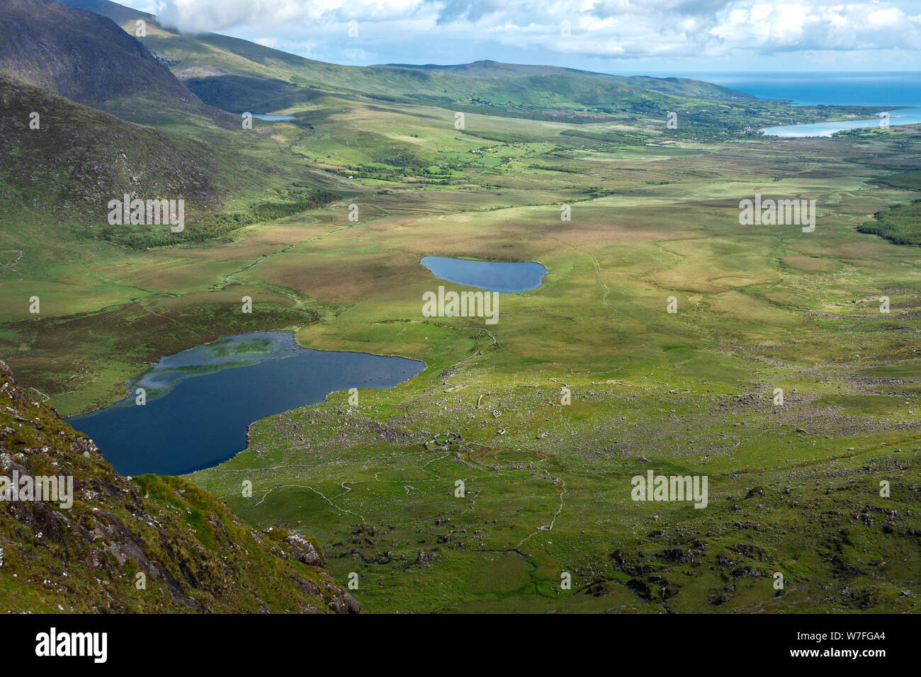 Vista sulla valle dalla sommità di Conor Pass verso Brandon Bay con Brandon montagne sulla sinistra - La penisola di Dingle, nella contea di Kerry, Repubblica di Irlanda Foto Stock
