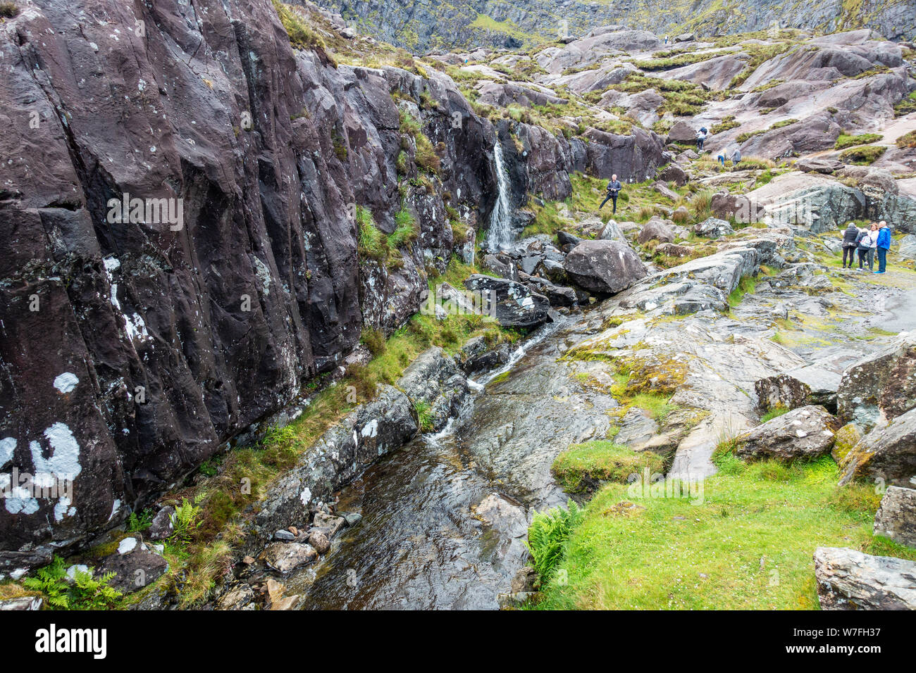 Una piccola cascata alimentata da Lough Doon a lato della strada in discesa da Conor Pass sulla penisola di Dingle, nella contea di Kerry, Repubblica di Irlanda Foto Stock