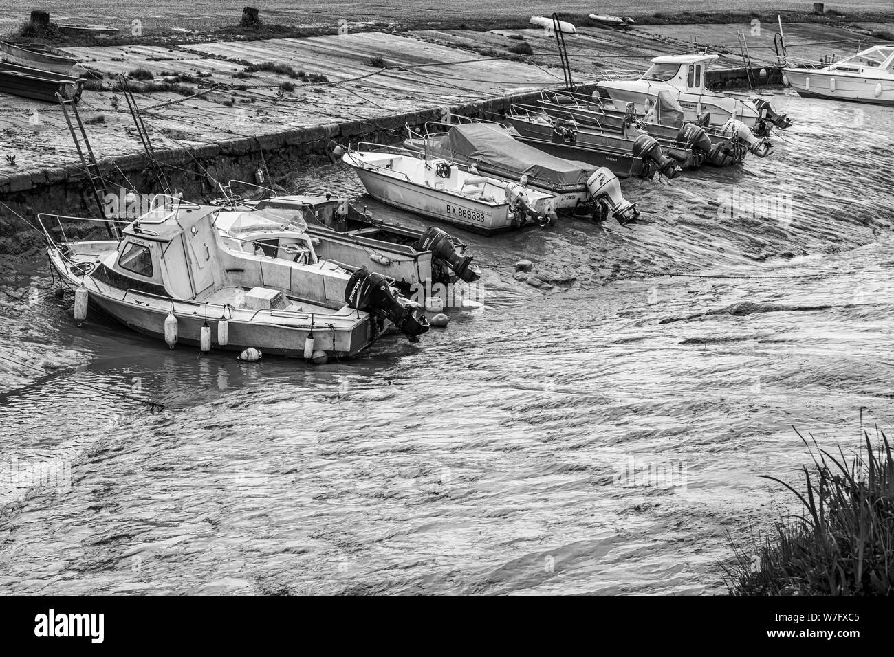 Piccole imbarcazioni si stabilirono su terreni fangosi appartamenti de La Saugeron estuario harbour con la bassa marea a Blaye, nei pressi di Bordeaux, in Gironde dipartimento di Francia. Foto Stock