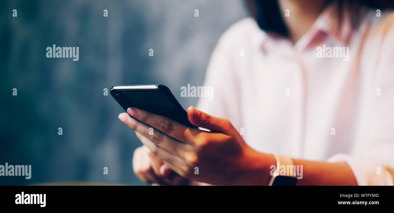 Donna che mantiene un smartphone, mock up del schermo vuoto. tramite telefono cellulare sul cafe. Tecnologia per il concetto di comunicazione. Foto Stock