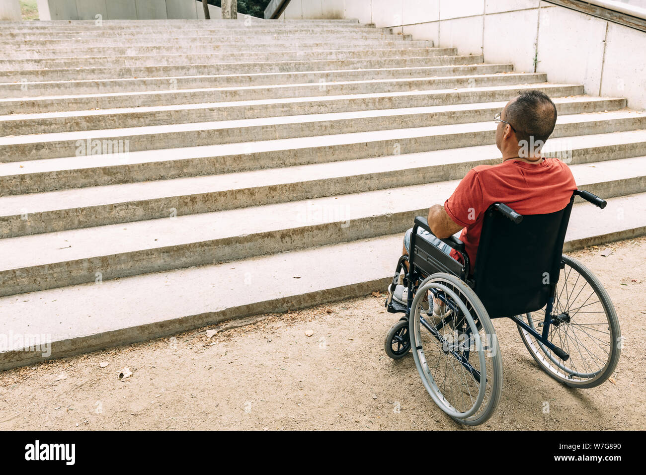 La persona disabile su sedia a rotelle fermato davanti alle scale che non  riesce a salire cercando di aiutare, sensibilizzazione delle barriere  architettoniche e accessib Foto stock - Alamy