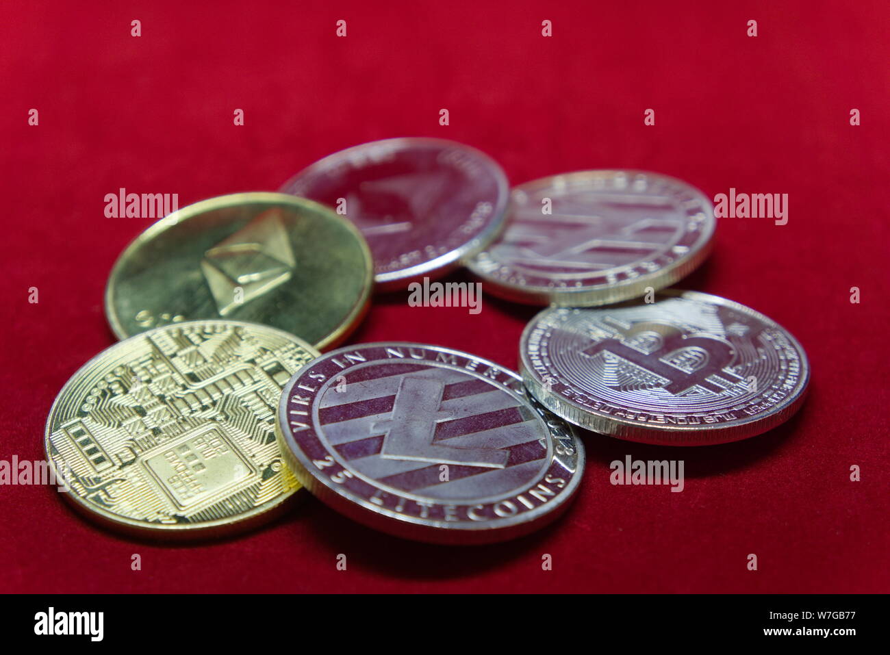 Close up di argento e di oro cryptocurrency con un velluto rosso sfondo impostato in un cerchio Foto Stock