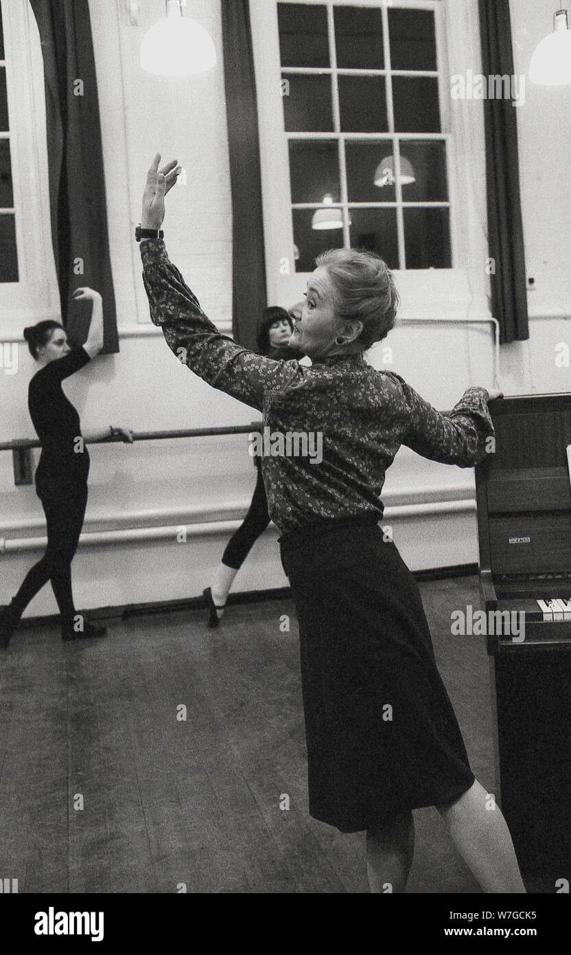 Anni Settanta, in corrispondenza di una classe di balletto. una signora anziana insegnante in piedi accanto a un piano indicante la classe come la posa deve cercare, Inghilterra, Regno Unito. Foto Stock
