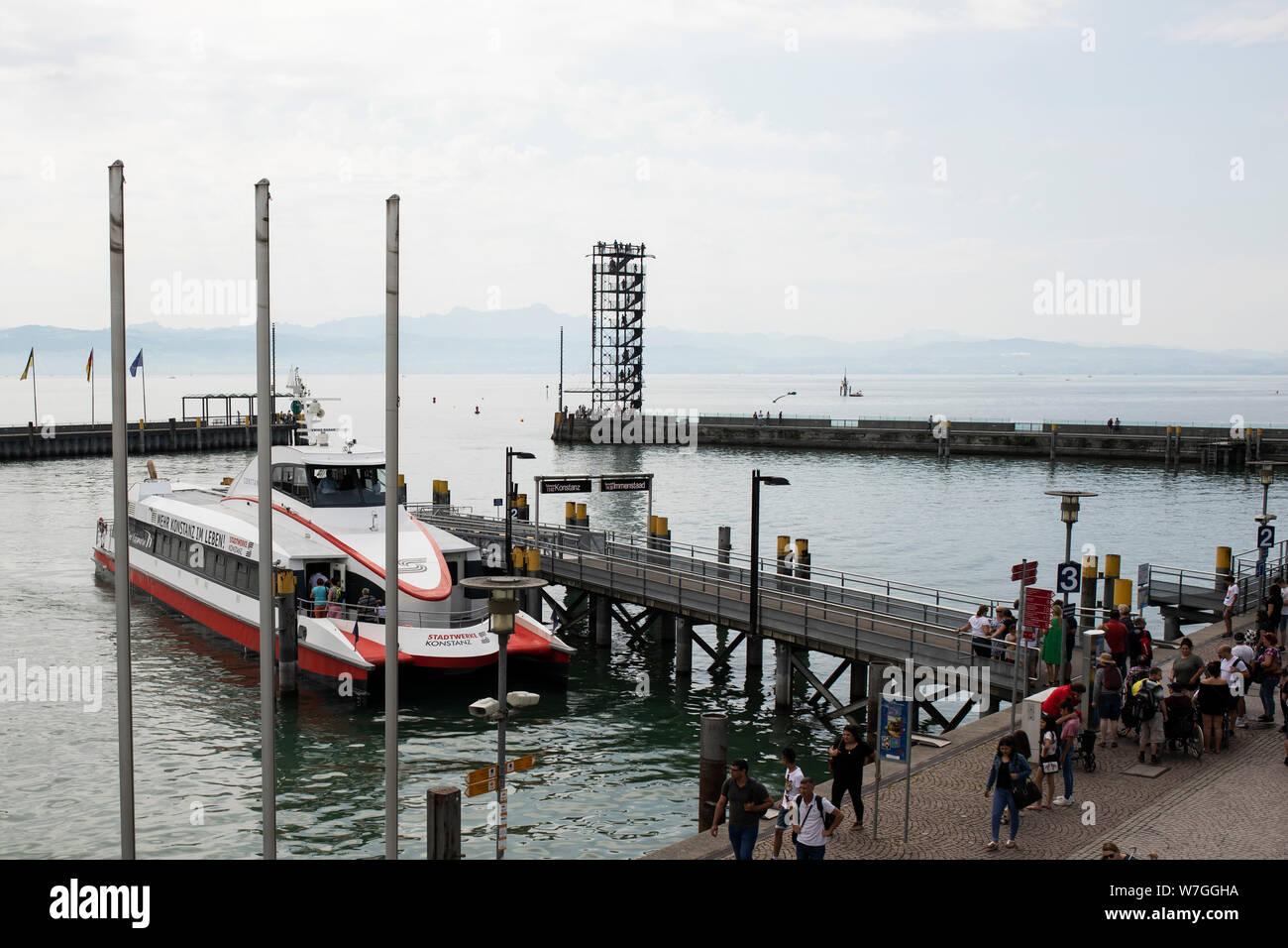 Una nave da crociera Katamaran attracca al lungomare di Friedrichshafen, in Germania, sul lago di Costanza con le Alpi svizzere sullo sfondo. Foto Stock