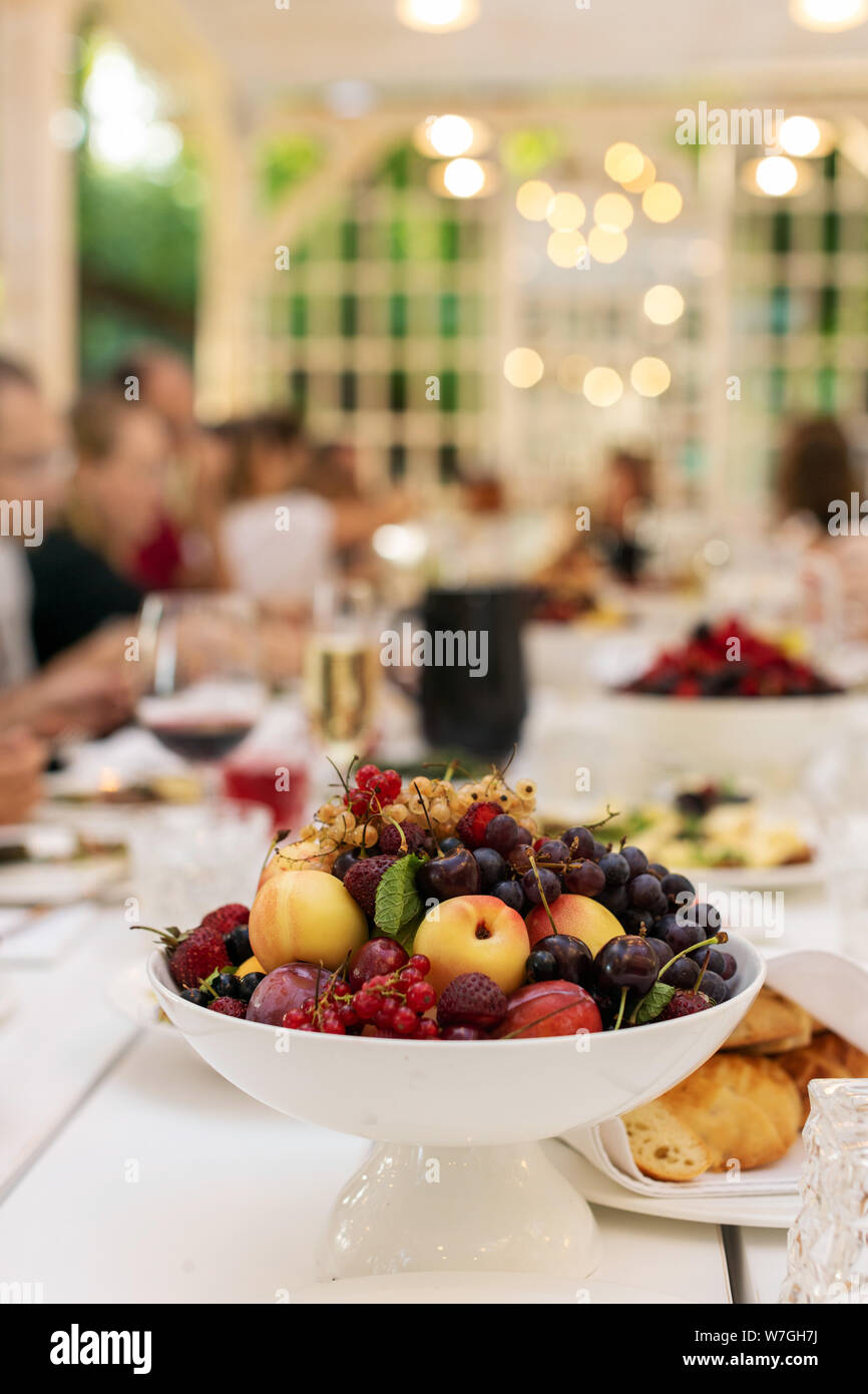 Ciotola bianco con frutta sulla tavola festiva Foto Stock