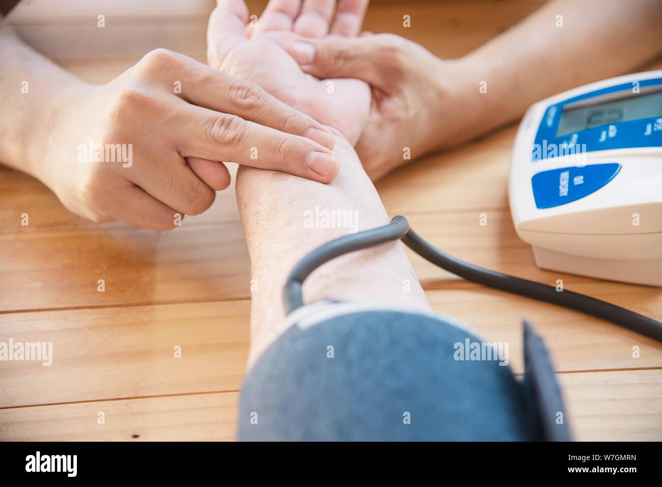 Old Lady è in fase di controllo della pressione sanguigna utilizzando monitor della pressione del sangue kid set - Persone con la salute cura medica di strumentazione concept Foto Stock