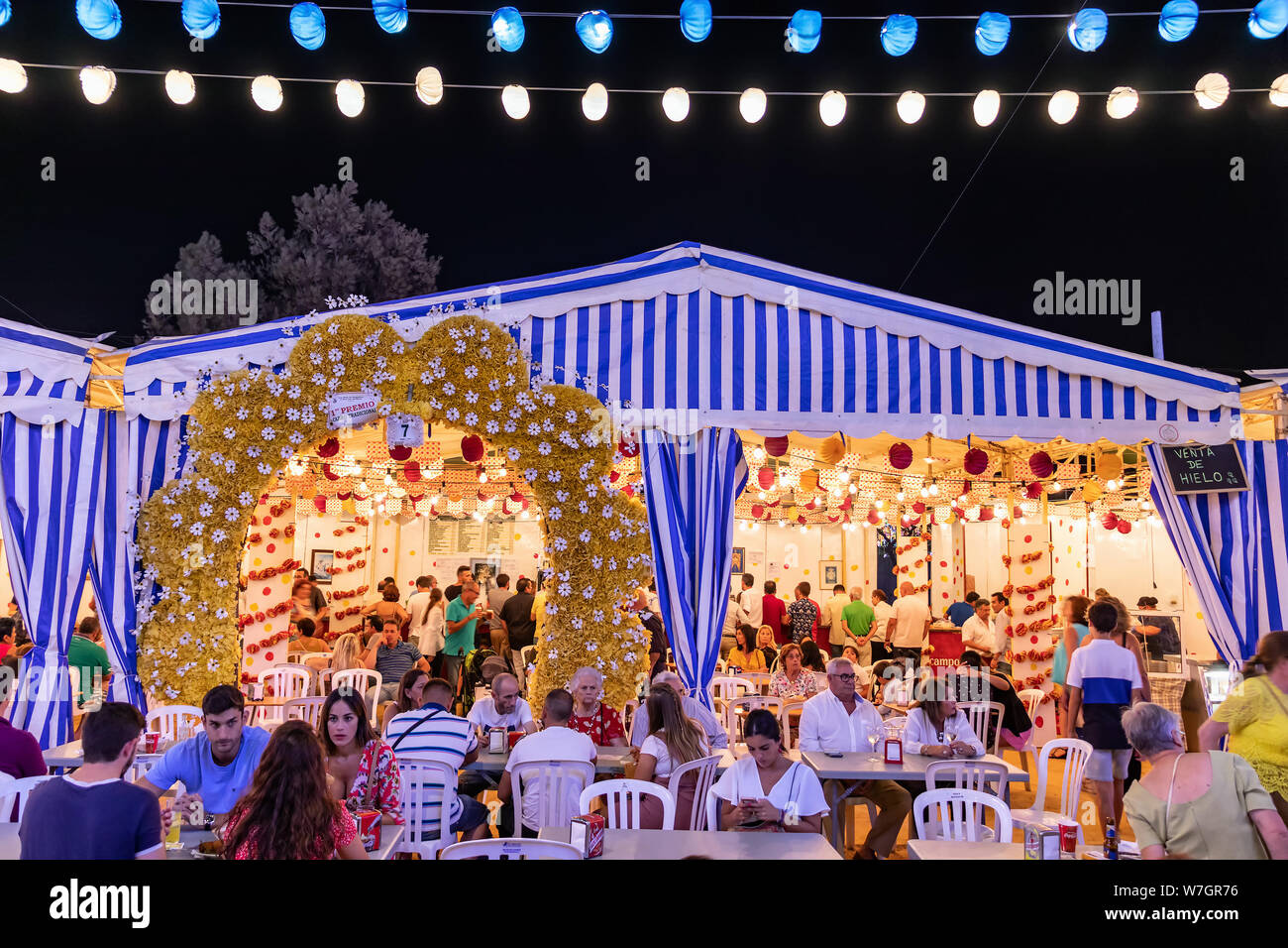 La gente di pranzare in un tradizionale 'caseta de feria' durante il festival colombiano (Fiestas Colombinas de Huelva), a commemo Foto Stock