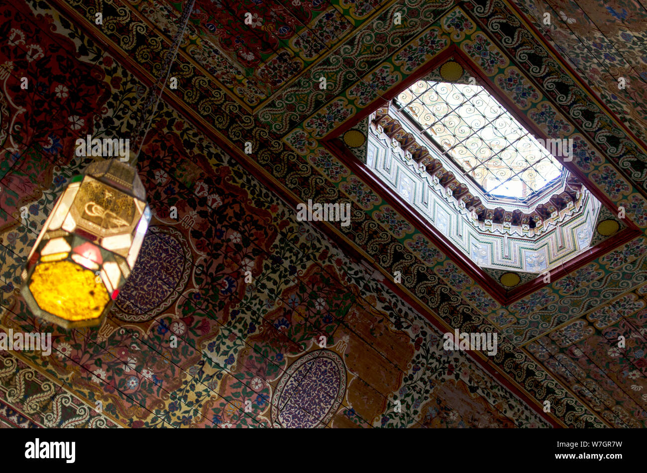 Con soffitto ligneo dipinto, con un'apertura all'esterno. Palazzo Bahia, Marrakech. Foto Stock