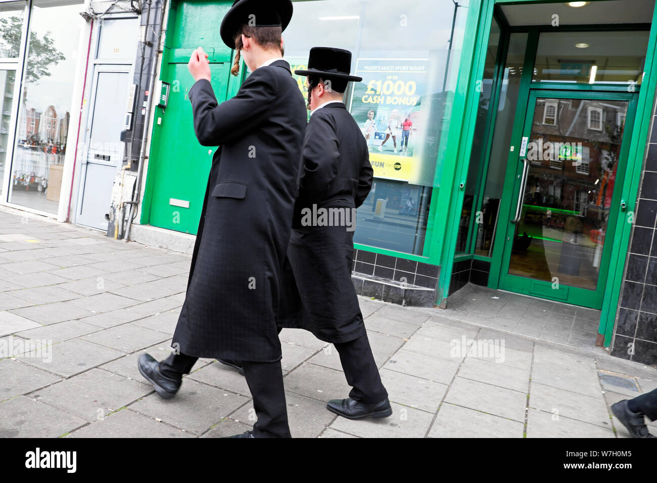 Vista posteriore di due ebreo Hasidic uomini camminando lungo la Stamford Hill high street a Londra del nord N16 Inghilterra UK KATHY DEWITT Foto Stock