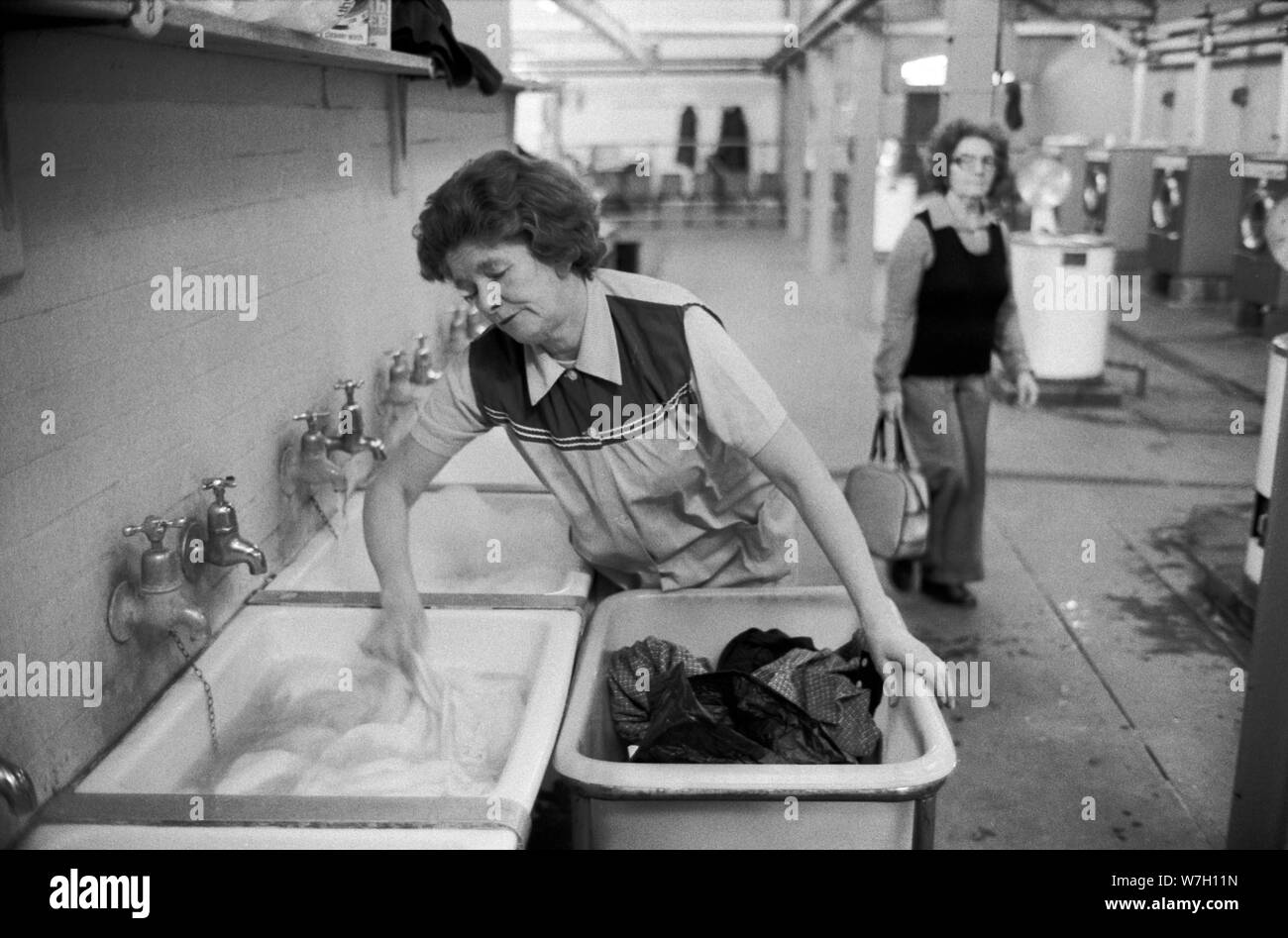 Servizio di lavanderia pubblico 1970 UK. Donne che prendono i loro vestiti usati sporchi ad una lavanderia pubblica per farli lavare. Battersea South London 1979 70s England HOMER SYKES Foto Stock