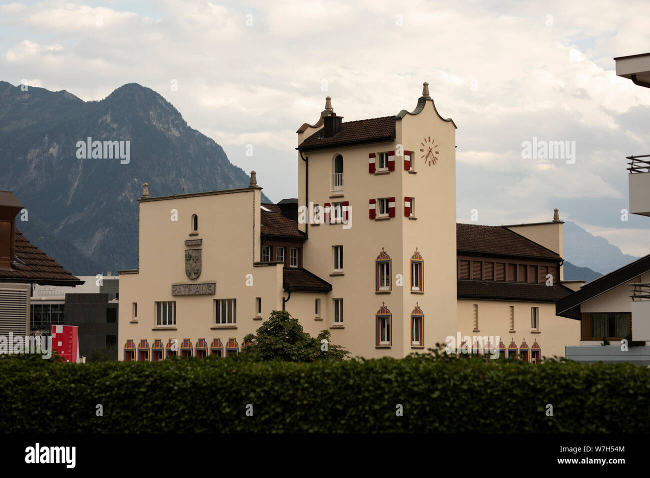 Municipio di Vaduz, Liechtenstein, nella parte anteriore delle Alpi e un cielo nuvoloso. Foto Stock