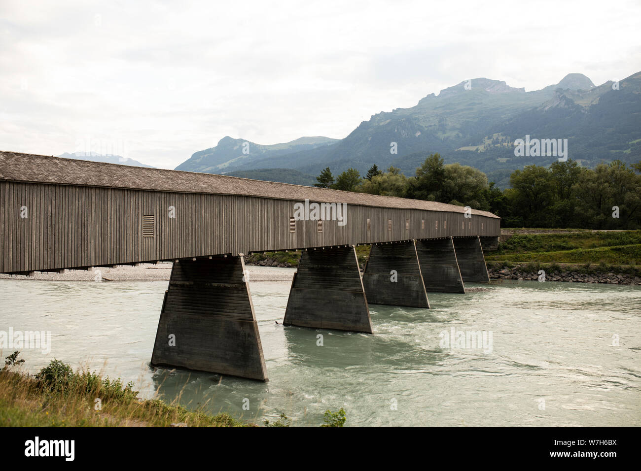 La Alte Rheinbrücke, un ponte coperto in legno che attraversa il Reno cercando da Vaduz, Liechtenstein, verso la Svizzera e le Alpi. Foto Stock
