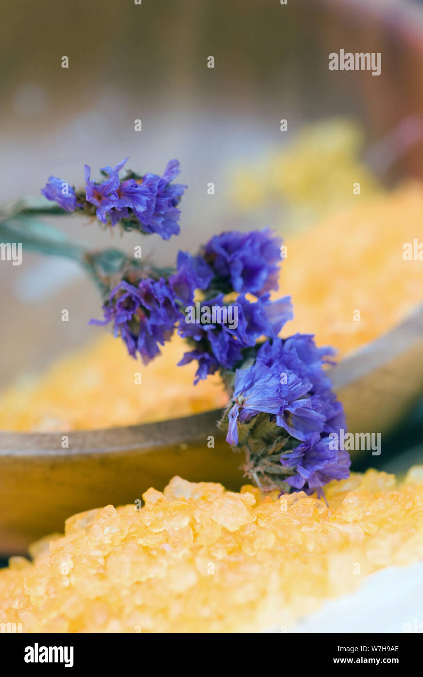 Atteggiamento Spa con giallo bagno aromaterapico sale e fiore blu sulla parte superiore Foto Stock