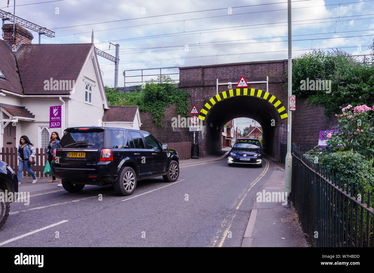 Una singola via tunnel sotto un ponte ferroviario dove le auto hanno per dare modo ai veicoli che sopraggiungono in senso contrario a Pangbourne, West Berkshire, Regno Unito Foto Stock