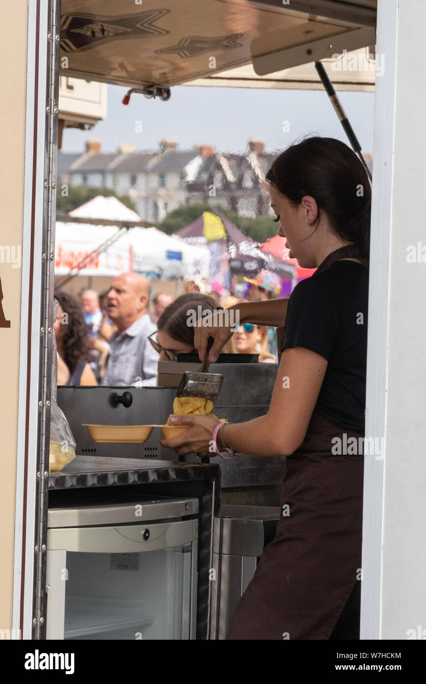 Un server di alimentare la cottura in un fast food van Foto Stock