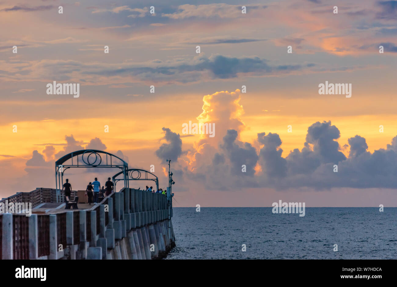 Colorate nuvole sunrise adornano l'orizzonte al di là di Lake Worth Pier a Lake Worth Beach in Palm Beach County, Florida. (USA) Foto Stock