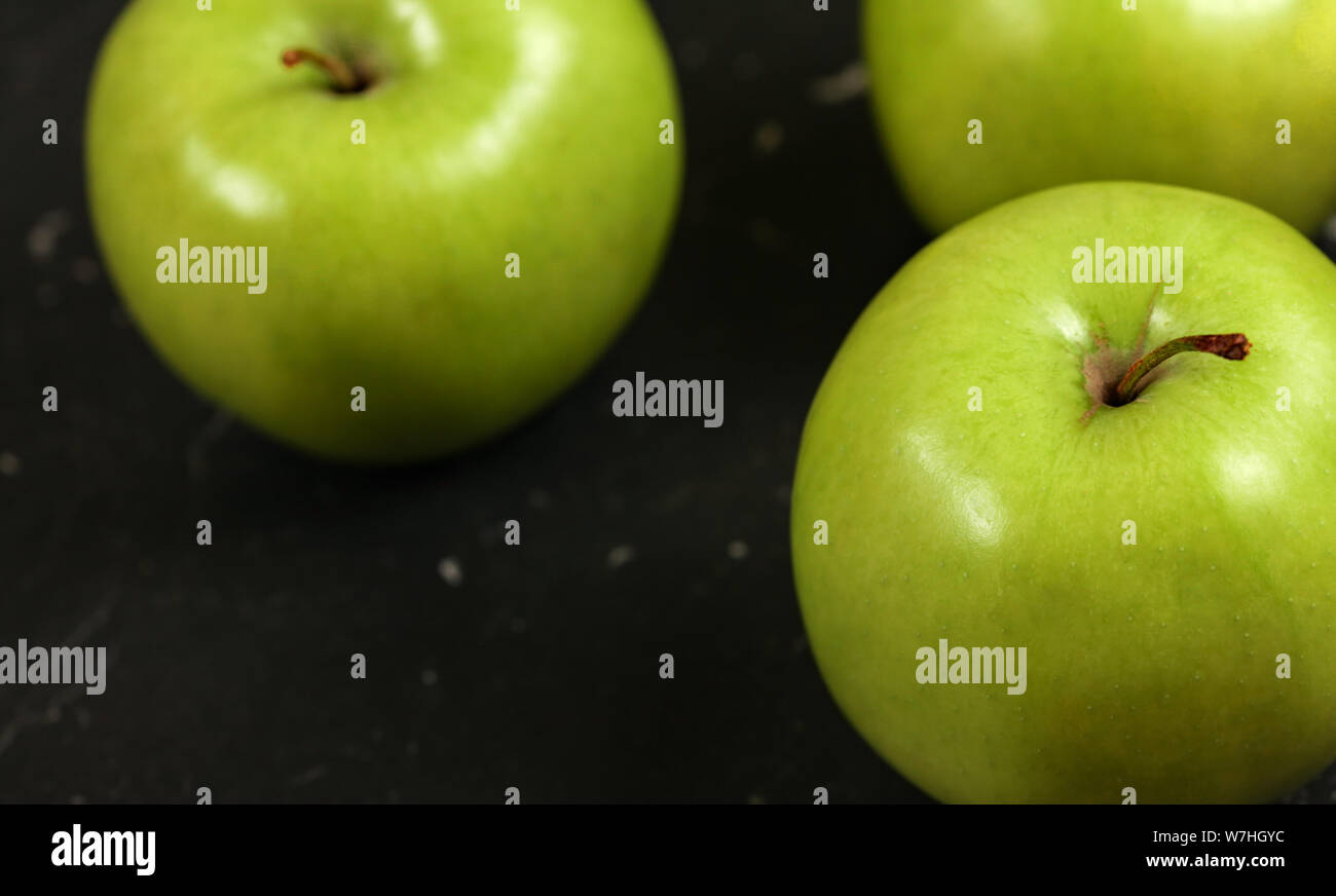 Close up foto, mele verdi sul bordo nero. Foto Stock
