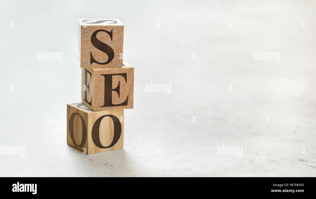 Palo con tre cubi di legno - lettere significato SEO ottimizzazione dei motori di ricerca su di essi, spazio per più di testo / immagini sul lato destro. Foto Stock