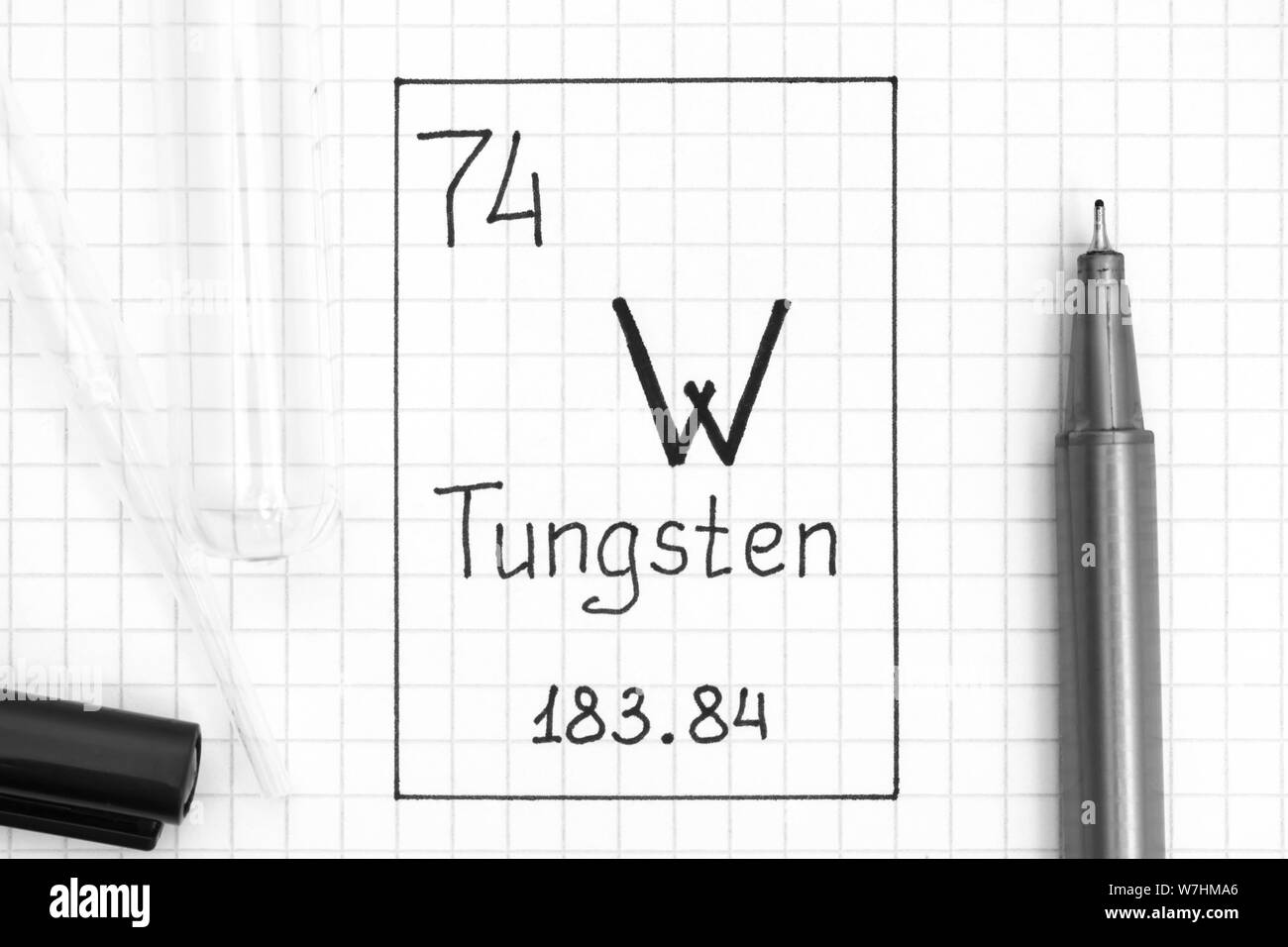 Tavola periodica degli elementi. La grafia elemento chimico Tungsten W con la penna nera, tubo di prova e la pipetta. Close-up. Foto Stock