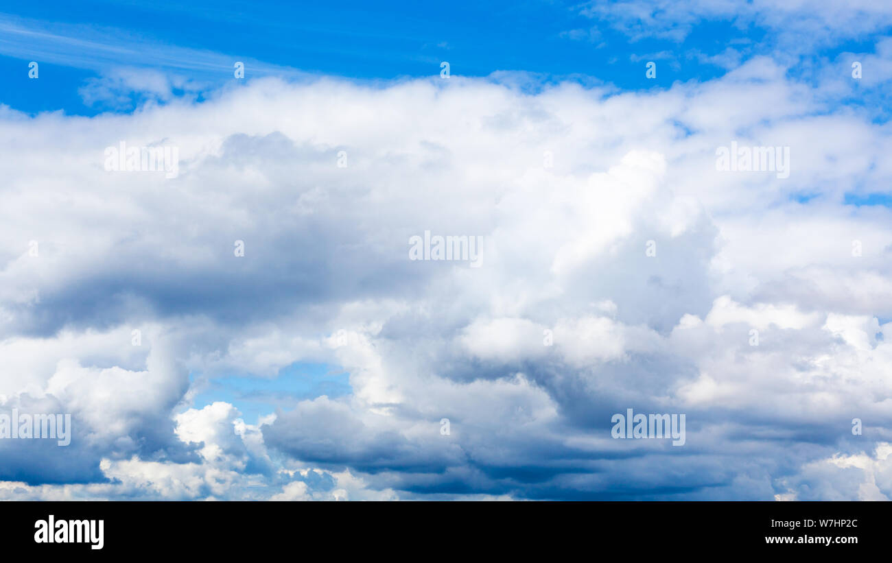 Sfondo naturale - bassa cumulus bianche nuvole nel cielo blu sul giorno di estate Foto Stock