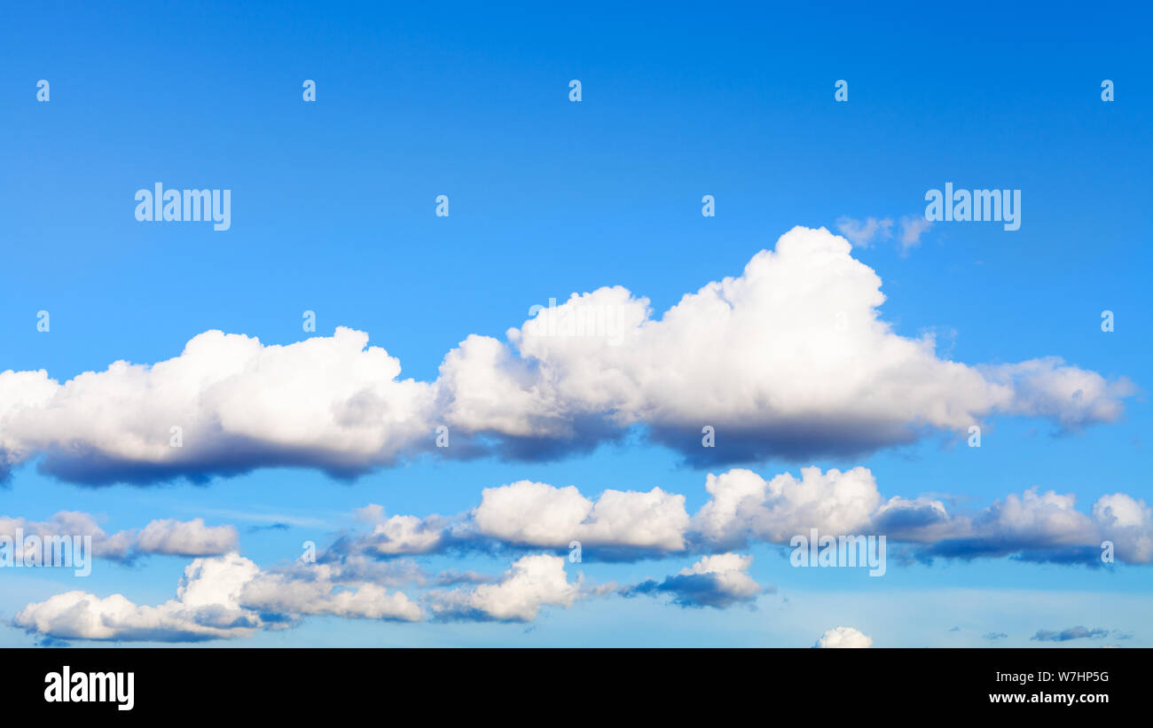 Sfondo naturale - catene di nuvole bianche nel cielo blu in serata estiva Foto Stock