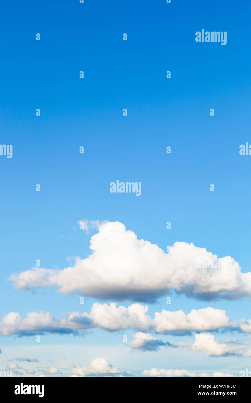 Naturale sfondo verticale - basse nuvole bianche nel cielo blu in serata estiva Foto Stock