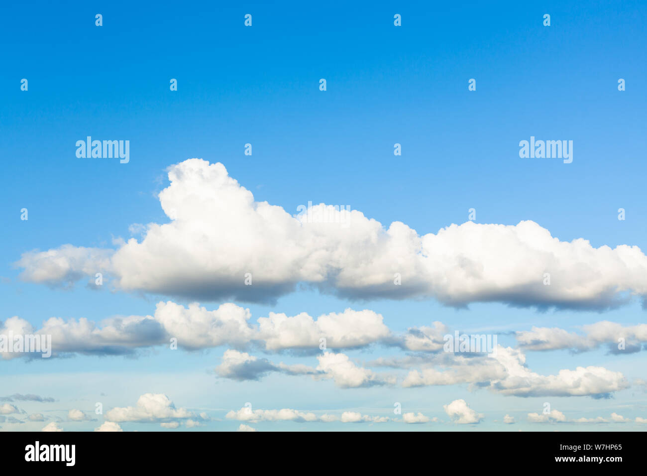 Sfondo naturale - catene di bianco e grigio nuvole nel cielo blu in serata estiva Foto Stock