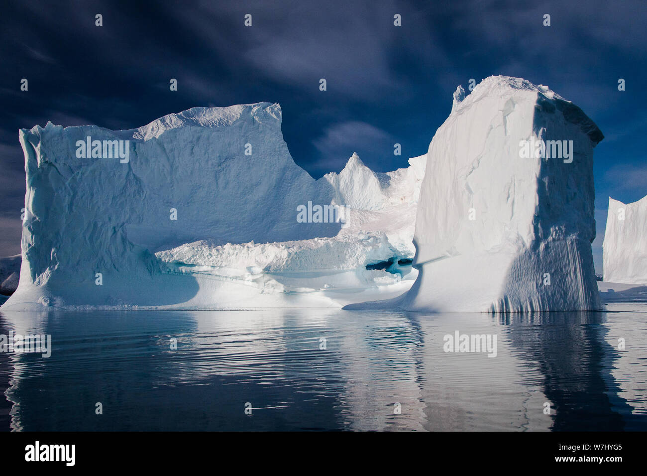 Della Groenlandia iceberg sono immense. Fino a 200 metri in altezza, e numerosi in volume. Ho preso al fiordo in in un zodiac desideroso di esplorare ulteriormente. Qui mi sono imbattuto in questo monumento di ghiaccio e immediatamente è stata rapita dalla sua tessitura, il contrasto e il colore intenso. Ho aspettato fino a quando le nuvole incorniciato iceberg in un modo etereo e ha avuto la possibilità di acquisire la mia immagine preferita Note: palmare su una crociera in zodiac Foto Stock