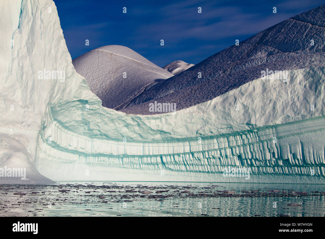 Un tubo di ghiaccio organ si dispiega quando si gira l'angolo in questo magnifico di ghiaccio scolpito bay, tubi ripetitive di seguito, pezzata campi sopra riportati, in RØdefjord, Groenlandia Foto Stock