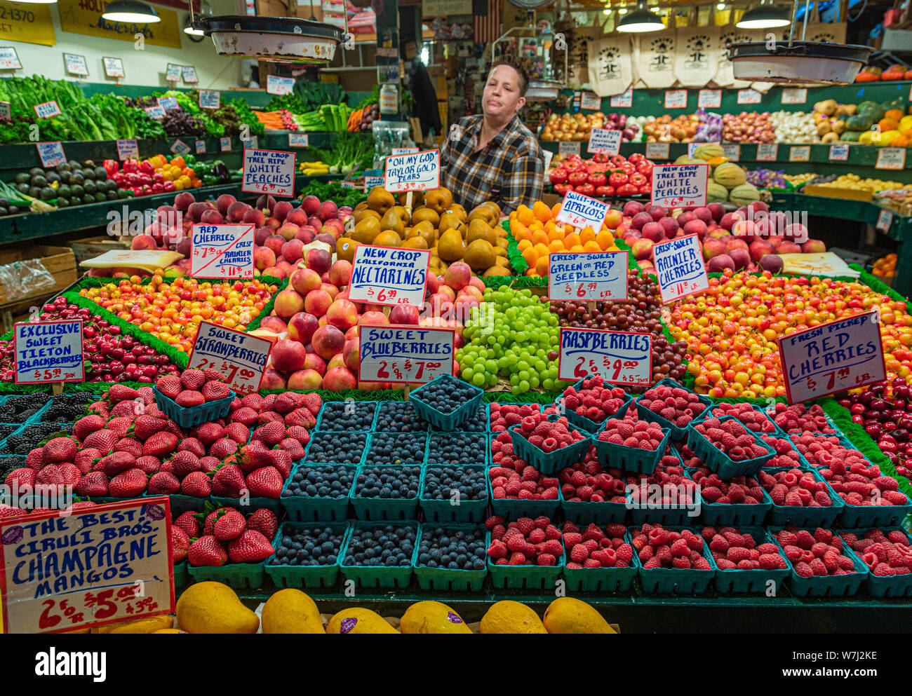 Venditore dietro il mercato della frutta Foto Stock