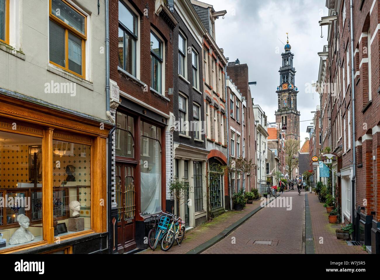 Strada con case in mattoni, vista di Westerkerk chiesa torre, quartiere Jordaan, Amsterdam, Olanda Settentrionale, Paesi Bassi Foto Stock
