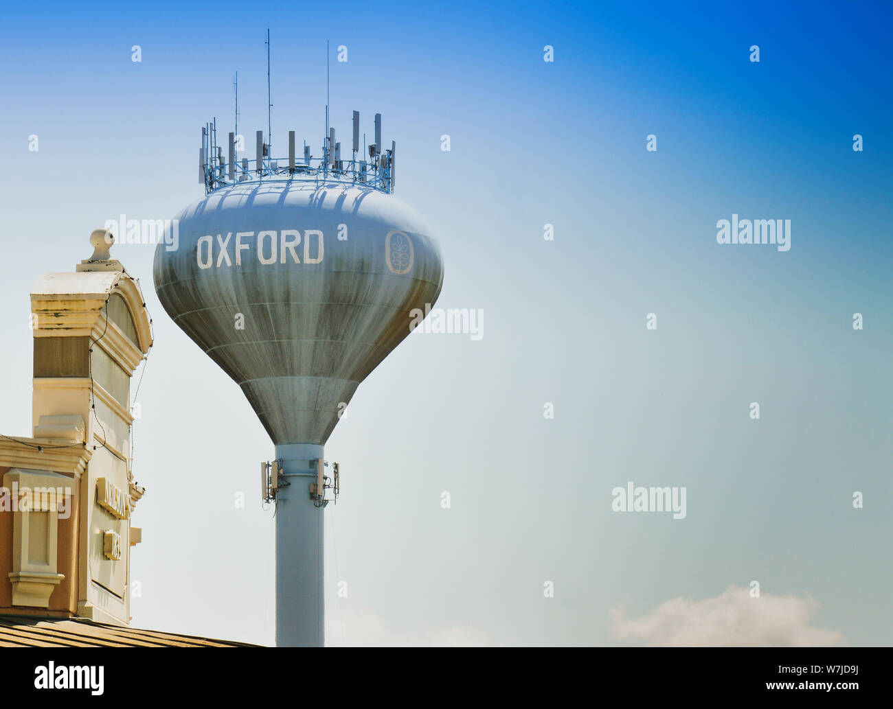 Un water tower con Oxford dipinto su di esso con un telefono cellulare di sistemi di comunicazione sulla parte superiore al di sopra della piazza nel centro di Oxford, MS, Foto Stock