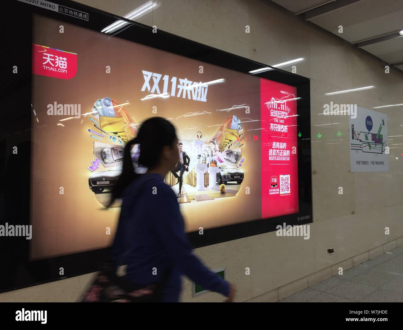 --FILE--un pedone passato passeggiate di un annuncio per il Tmall 11.11 online shopping festival a una stazione della metropolitana di Pechino, Cina, 24 ottobre 2015. Foto Stock