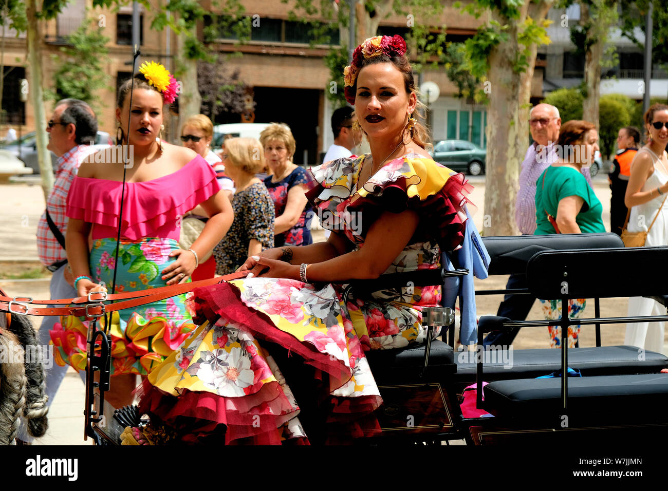 Le donne nel tradizionale costume spagnolo su un carro trainato da cavalli (enganche), parte del Corpus Domini celebrazione in Granada, Spagna. Foto Stock