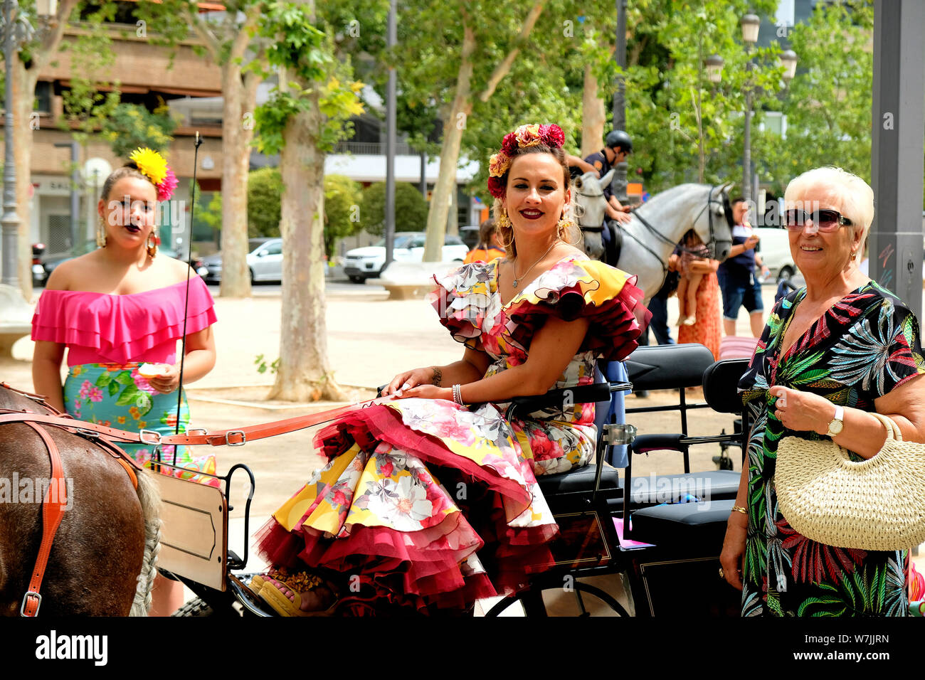 Le donne nel tradizionale costume spagnolo su un carro trainato da cavalli (enganche), parte del Corpus Domini celebrazione in Granada, Spagna. Foto Stock