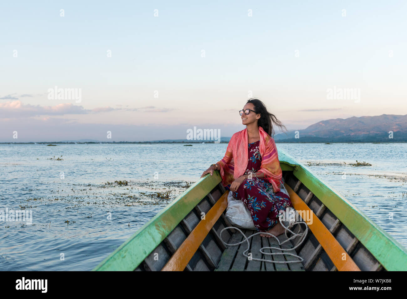 Immagine orizzontale di una bella turista straniero cercando le tranquille acque del Lago Inle durante una gita in barca, Myanmar Foto Stock