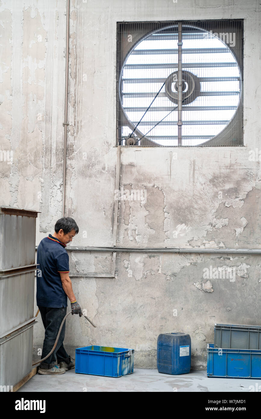 Fabbrica cinese lavoro benna si riempie di acqua in un materiale metallico quale acciaio inossidabile fabbrica vicino a Shanghai, Cina. Foto Stock