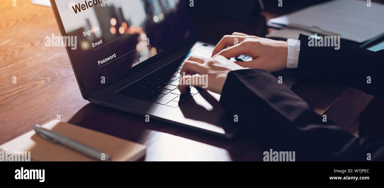 Business donna mani digitando su computer laptop con sign up e la password per il sito web on-line. Foto Stock