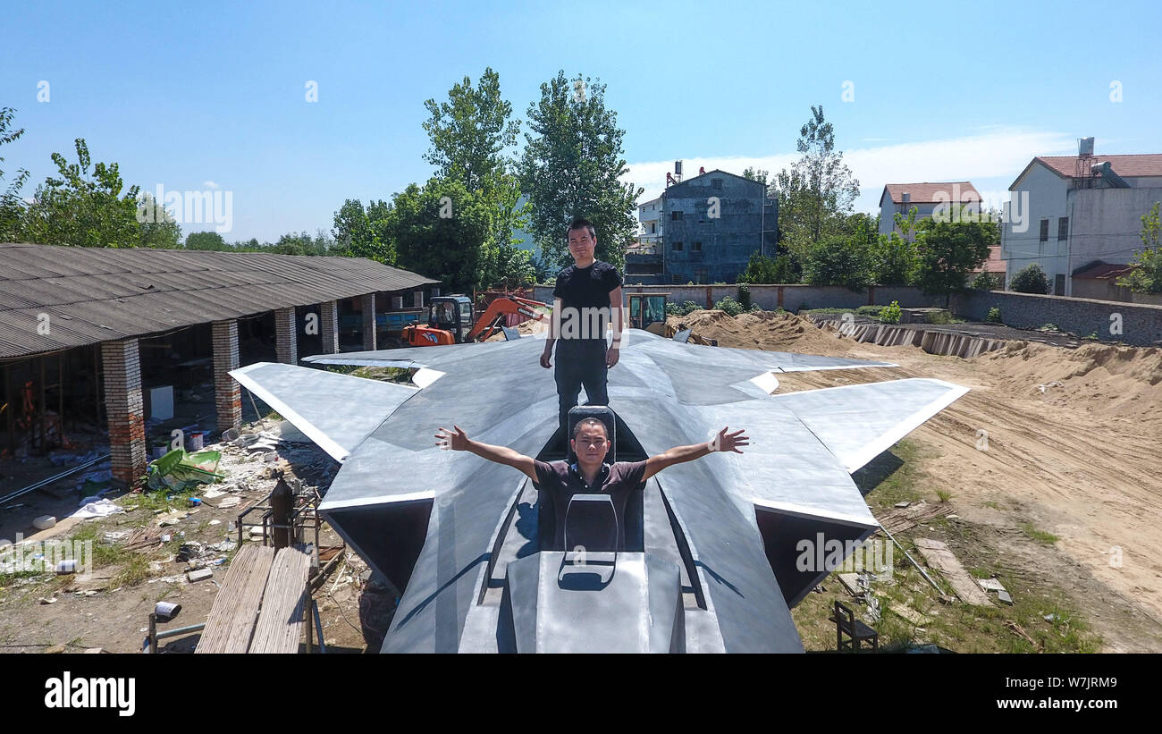 Modello cinese per gli appassionati di aerei Wan Li, superiore e Gu Chunlin posano con il modello a grandezza del J-20 Stealth Fighter Aircraft cinese di PLA (pers Foto Stock