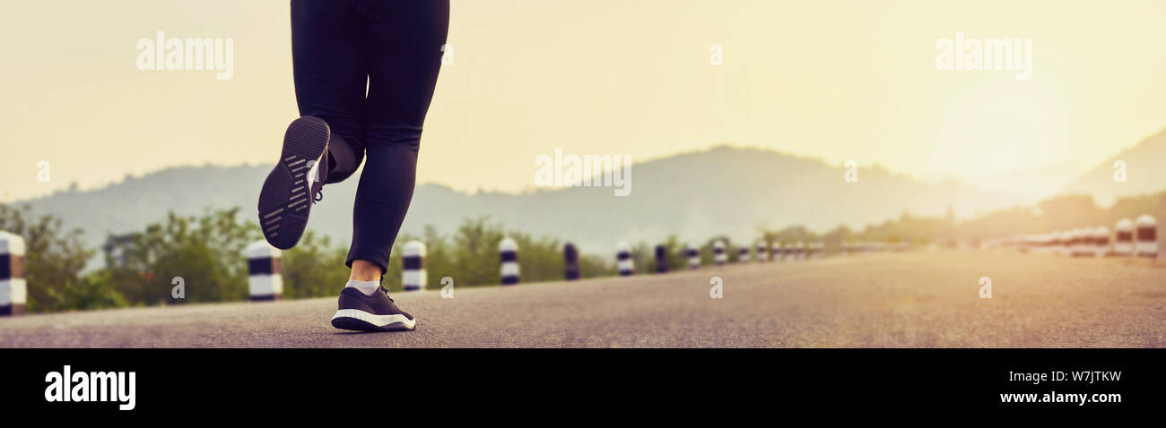 Close up della donna della gamba in esecuzione di avviare per raggiungere l'obiettivo. Jogging allenamento sport e stile di vita sano concetto. proporzione del banner per gli annunci. Foto Stock