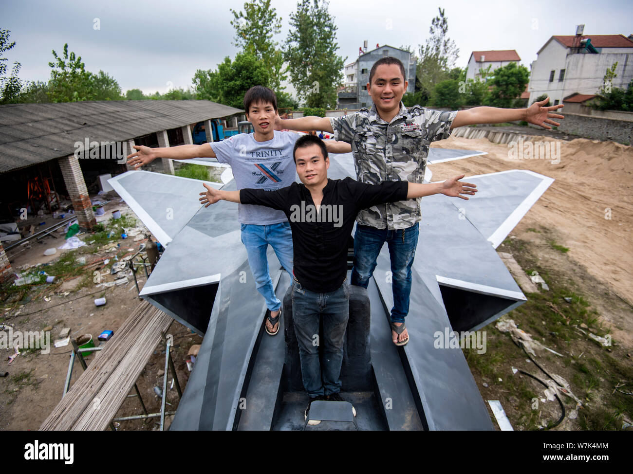 Cinese gli appassionati di militari Wan Li, anteriore, Gu Chunlin, torna a destra e Huang Aibo, posteriore sinistra, posano con il modello a grandezza del J-20 stealth lotta Foto Stock