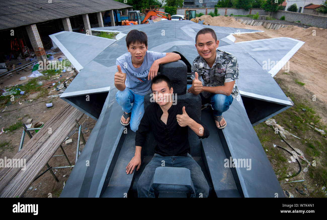 Cinese gli appassionati di militari Wan Li, anteriore, Gu Chunlin, torna a destra e Huang Aibo, posteriore sinistra, posano con il modello a grandezza del J-20 stealth lotta Foto Stock