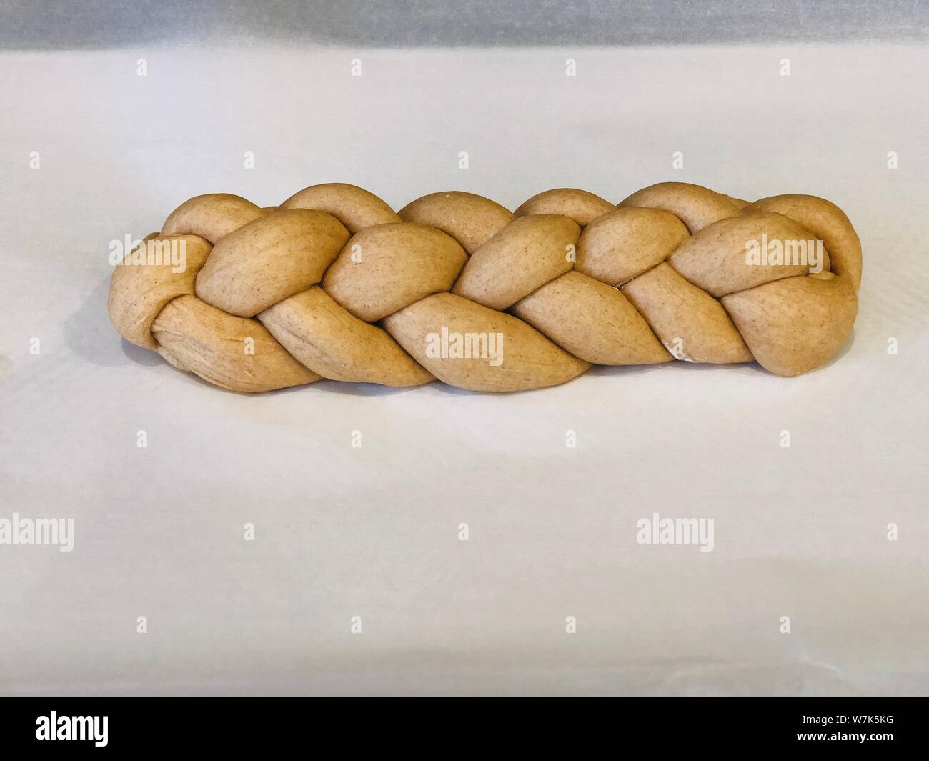 Supporto challah in casa pane di pasta intrecciata prima della sua supportato su un supporto cartaceo Foto Stock Supporto challah in casa pane di pasta intrecciata prima della sua supportato su un supporto cartaceo Foto Stock