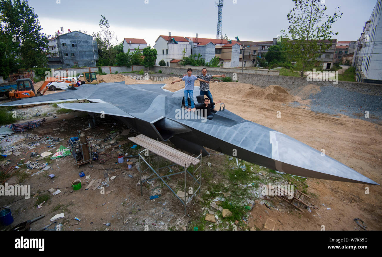 Cinese gli appassionati di militari Wan Li, anteriore, Gu Chunlin, torna a destra e Huang Aibo, posteriore sinistra, posano con il modello a grandezza del J-20 stealth lotta Foto Stock