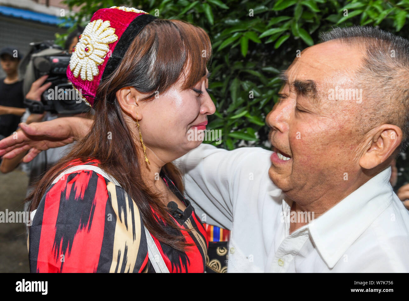 Il 33-anno-vecchio Genakuli Mahamat dal Xinjiang, abbracci la sua " padre " Li Zhongyi che ha aiutato il suo ritorno a casa dopo essere stata persa a Chengdu 21 anni fa Foto Stock